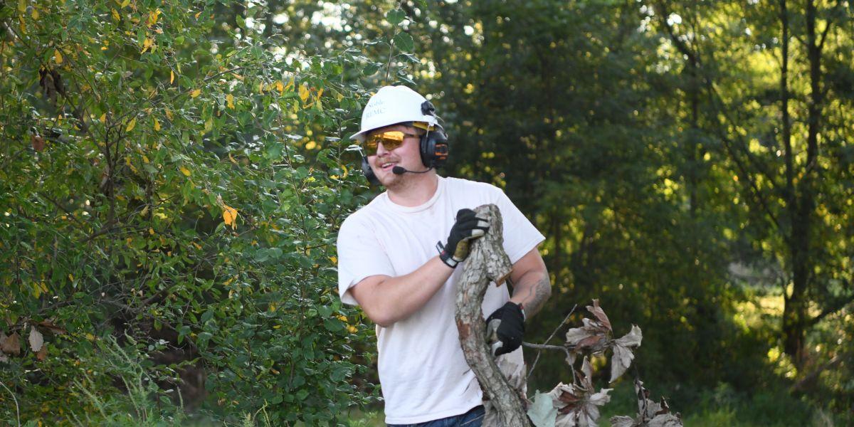 Tyler Gump dragging a branch